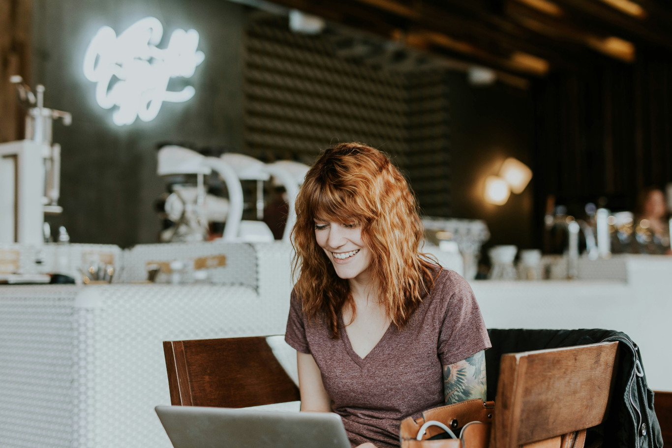 A smiling person using a laptop